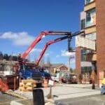 Two Knez boom trucks operating at a job site